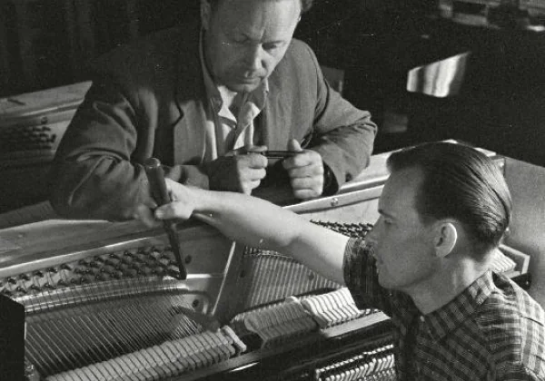 Técnicos afinando piano en el taller de Kalamaja